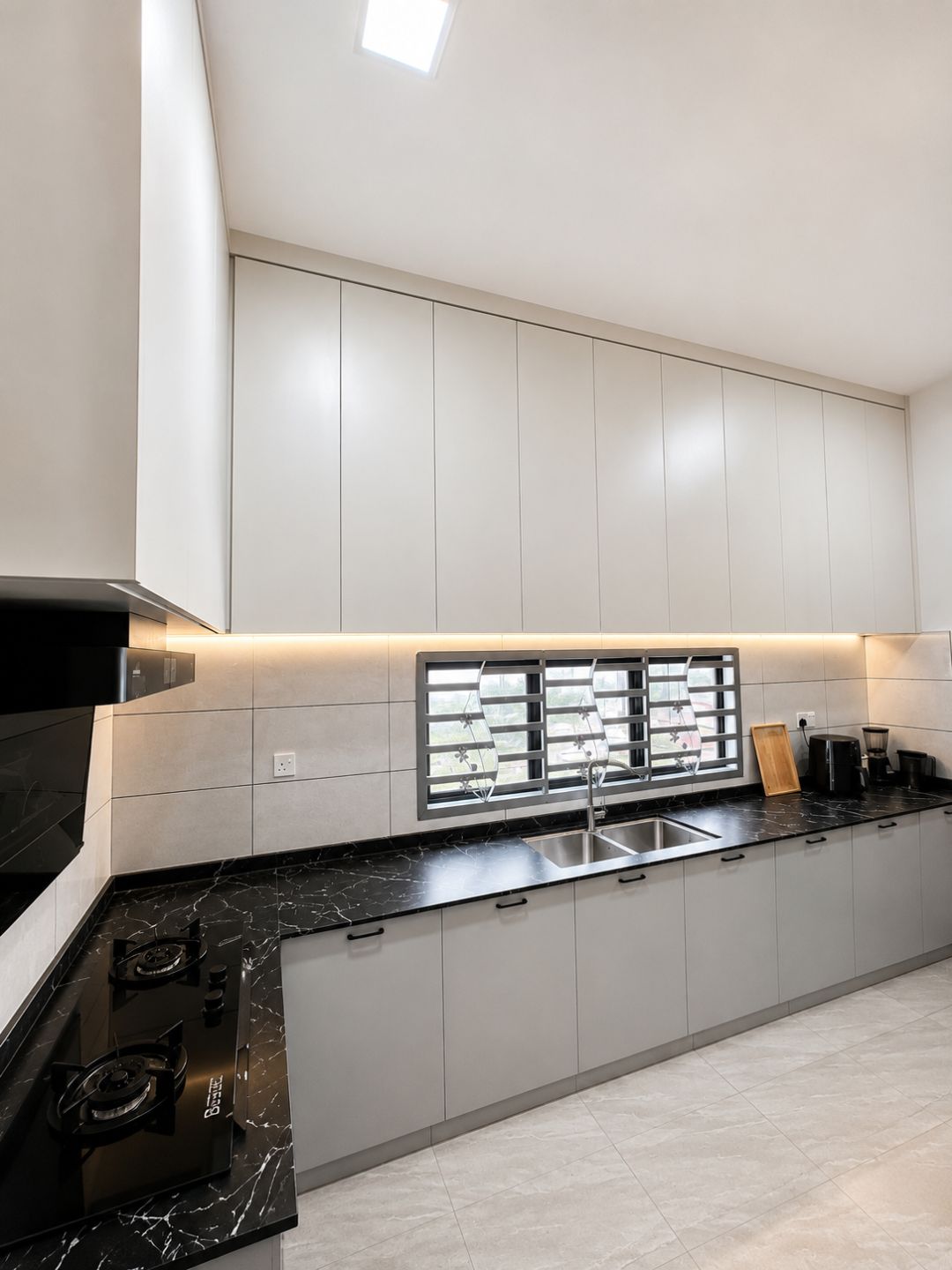 Full-height white wall cabinets with soft-grey base units and black marble top.