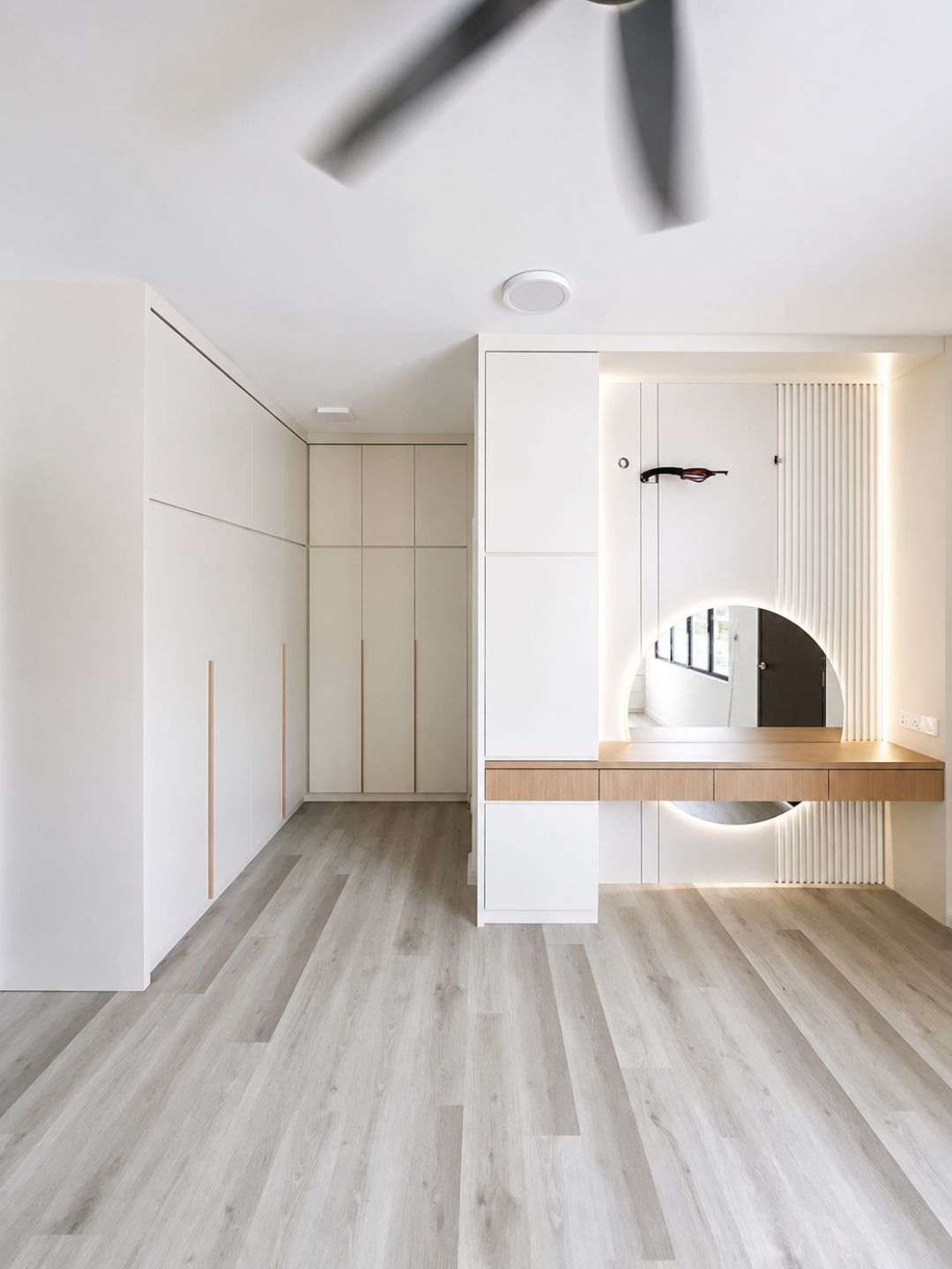 Walk-in wardrobe with vanity and round LED mirror