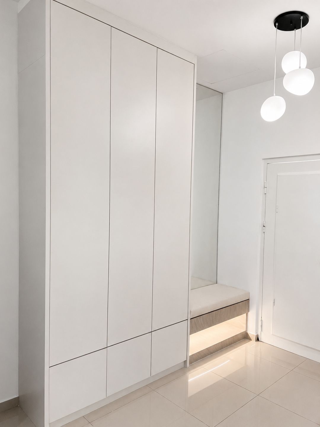 Floor-to-ceiling wardrobe with dressing bench and pendant lights