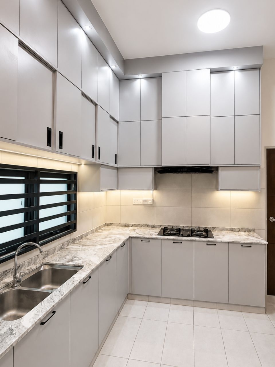 L-shaped kitchen with marble-look countertop and LED strip lighting