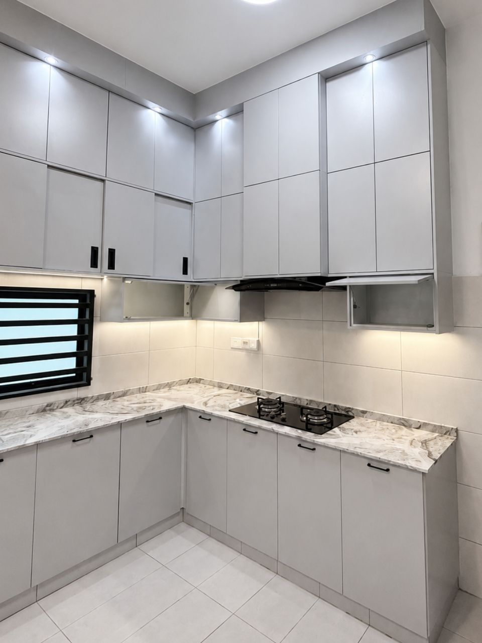 Corner angle showing the gas hob, built-in cooker hood and slim black bar handles